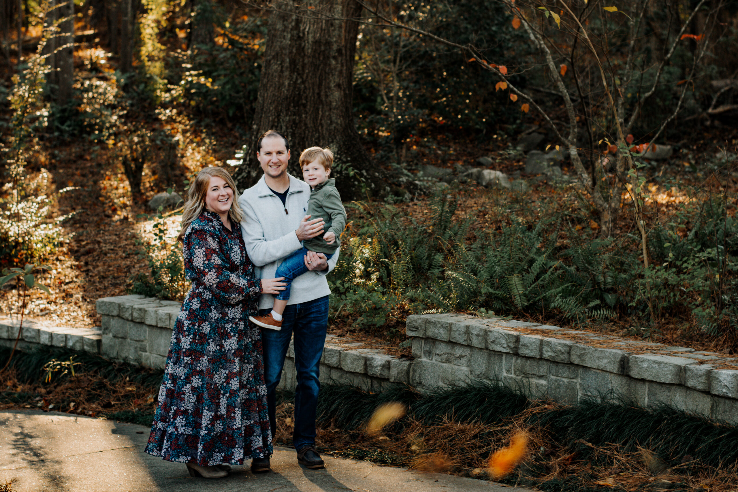 Family poses in front of brick wall in during family photoshoot