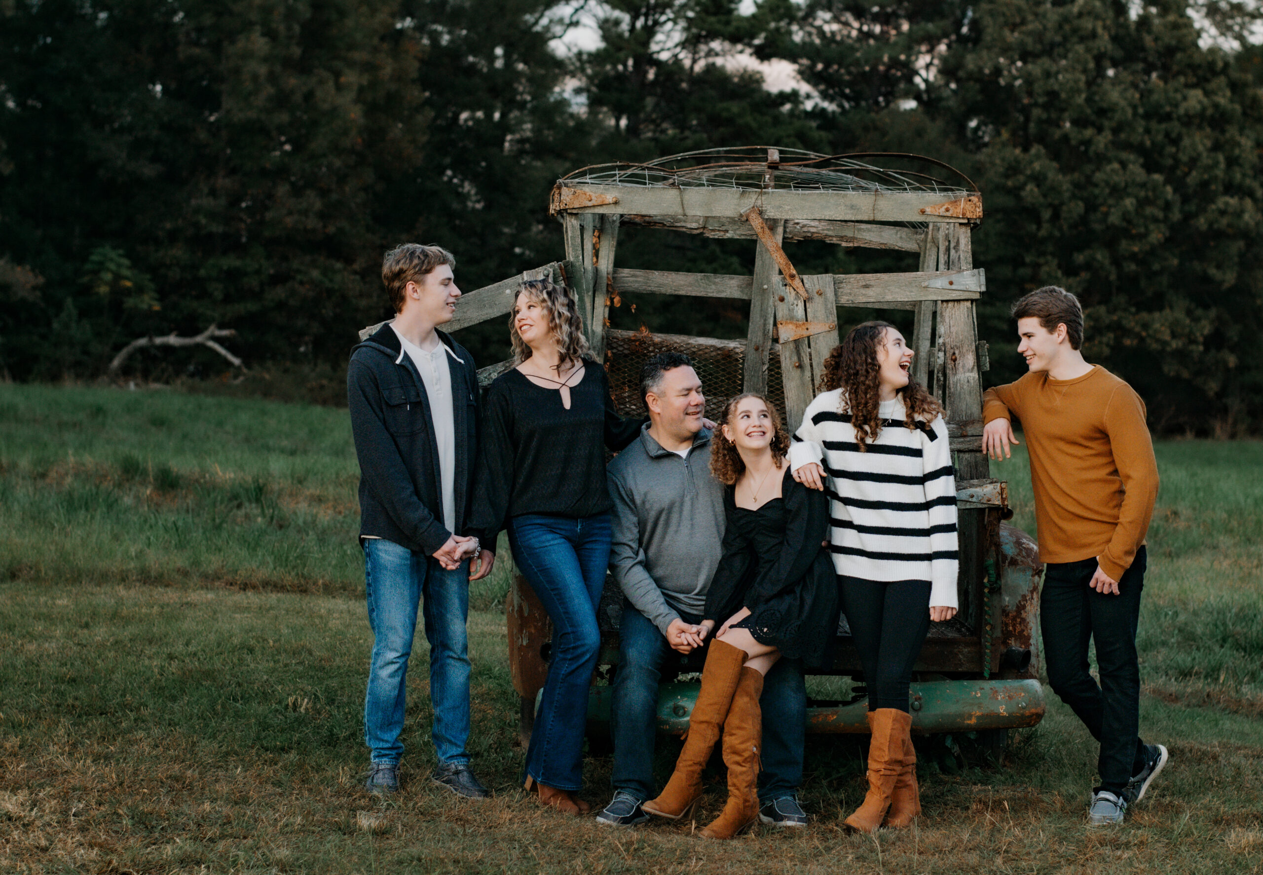 Family poses on old truck in field in Stonecrest, Georgia