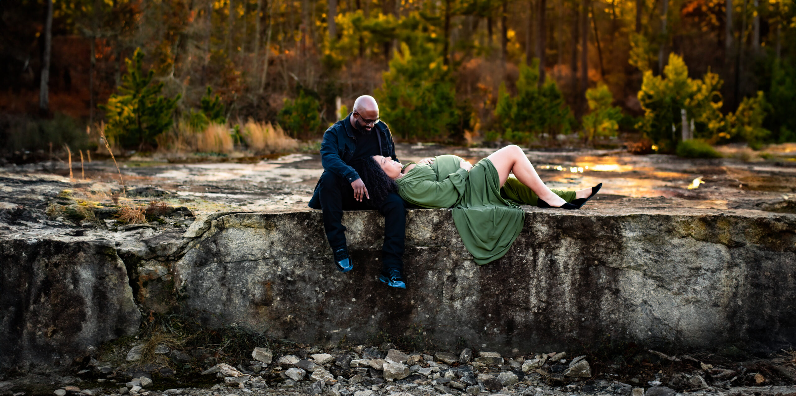Mom lays in dad's lap during Arabia Mountain maternity session