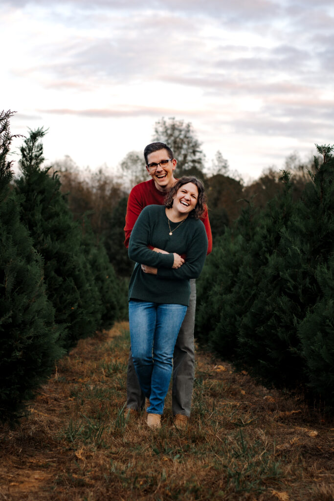 Couple hugs at Christmas tree farm