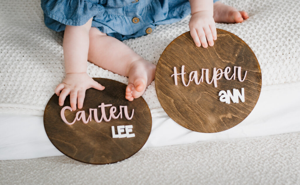 View of two child hands holding name plaques