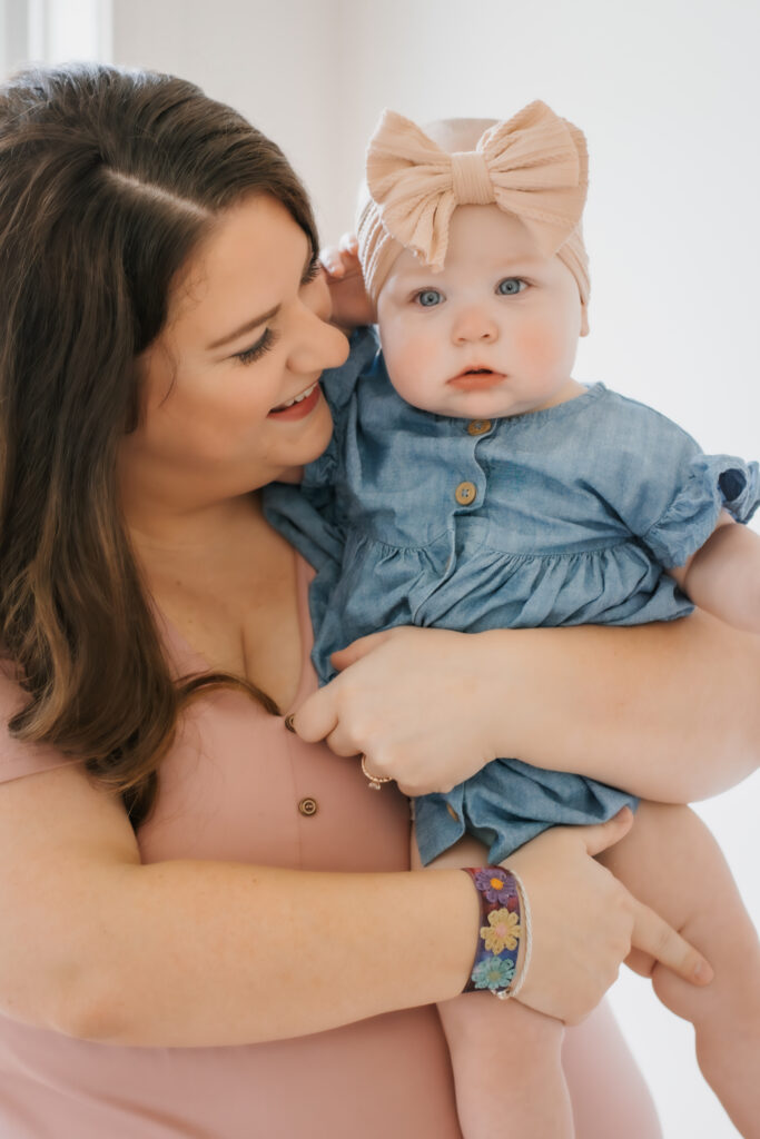 Mom in pink dress holds daughter