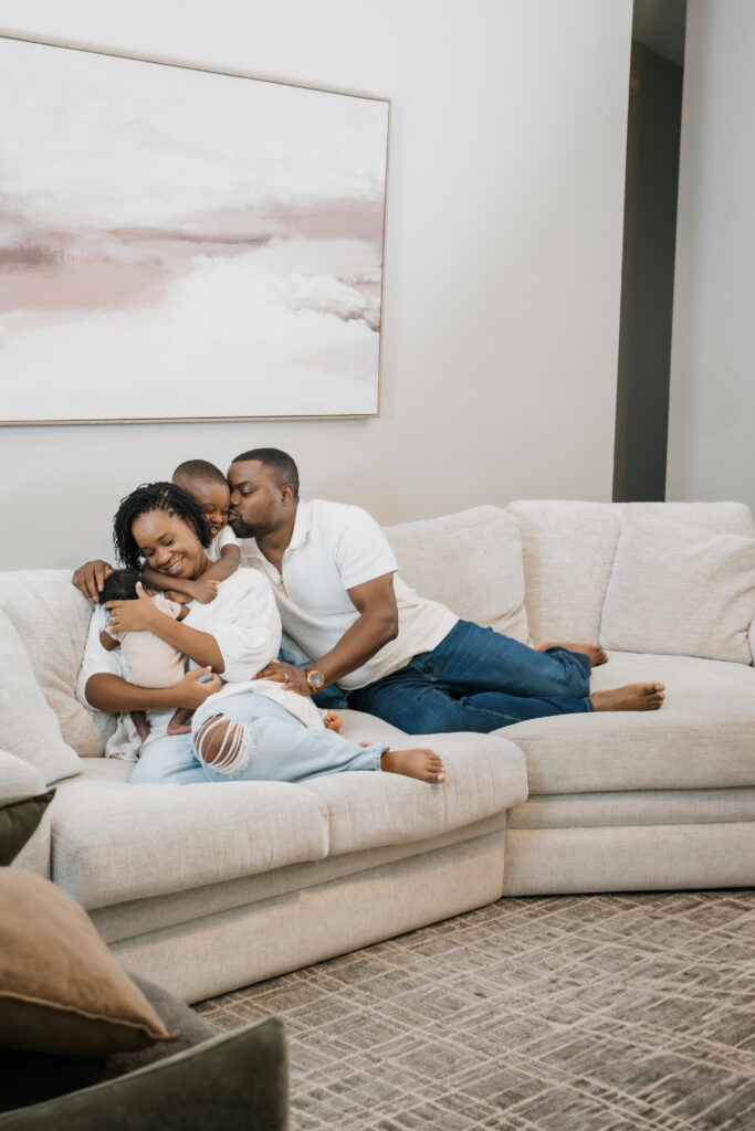 Family piled on couch during Atlanta newborn session at home