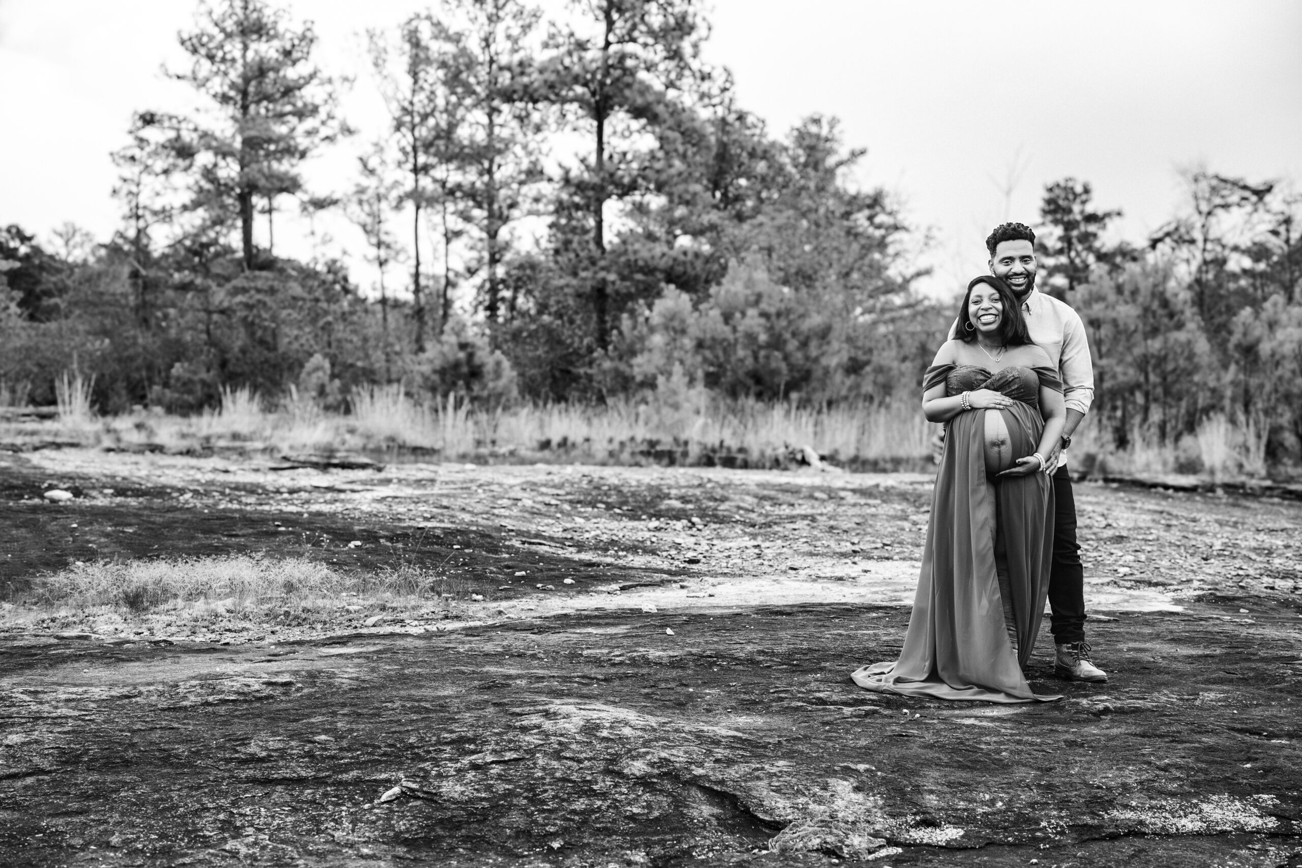 Couple stands on Arabia Mountain during maternity photo session