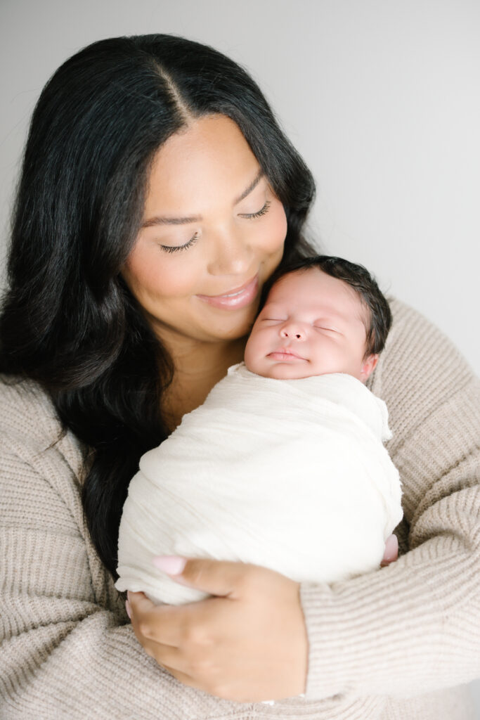 New mom cradles her baby and smiles down at her