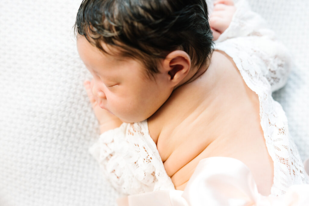 Newborn sleeping on a posing bed shot from above.