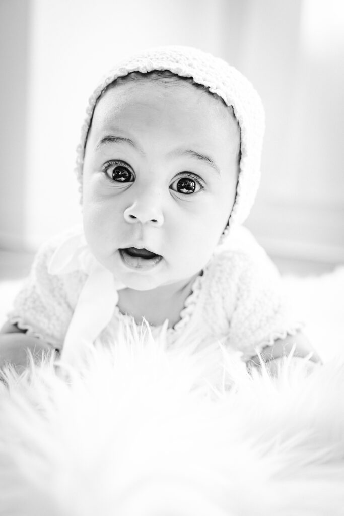 black and white portrait of six month on on her tummy smiling at the camera