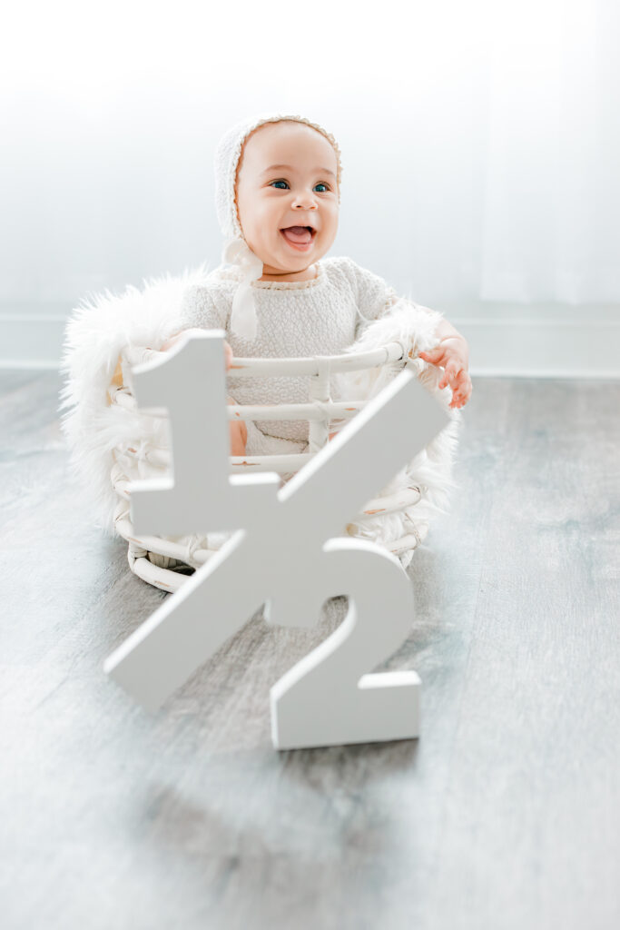 Little girl and a 1/2 wooden sign during milestone photoshoot