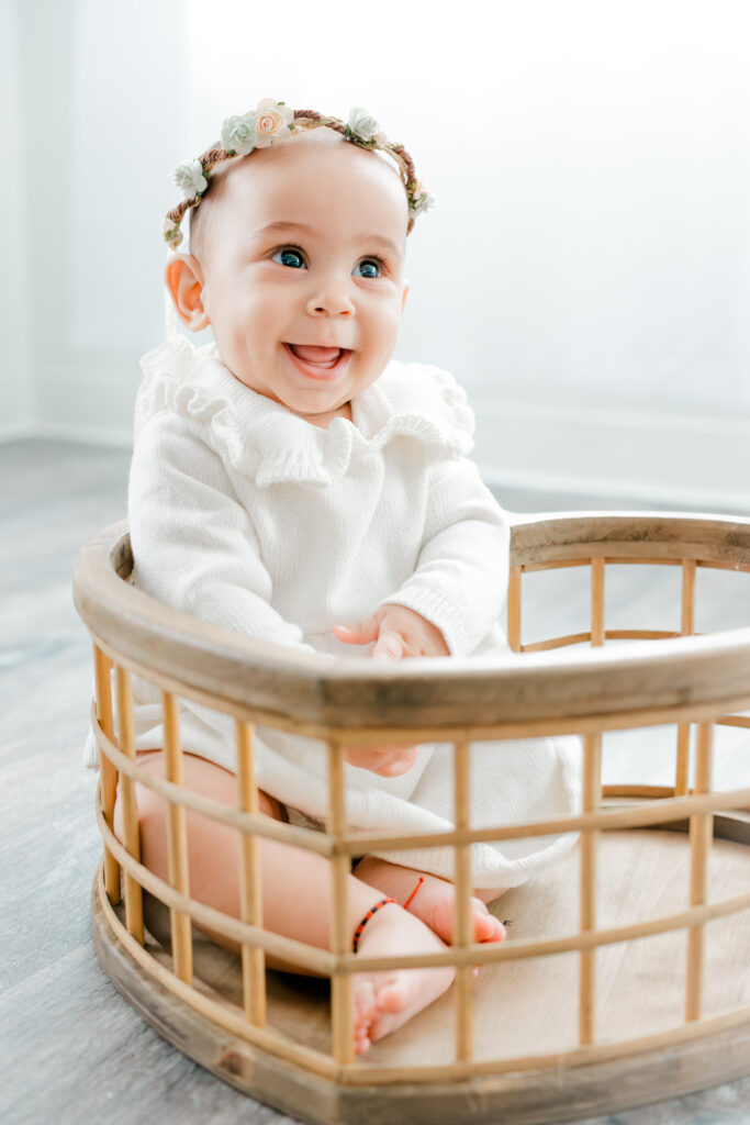 Baby in heart cage with flower crown during six month milestone session