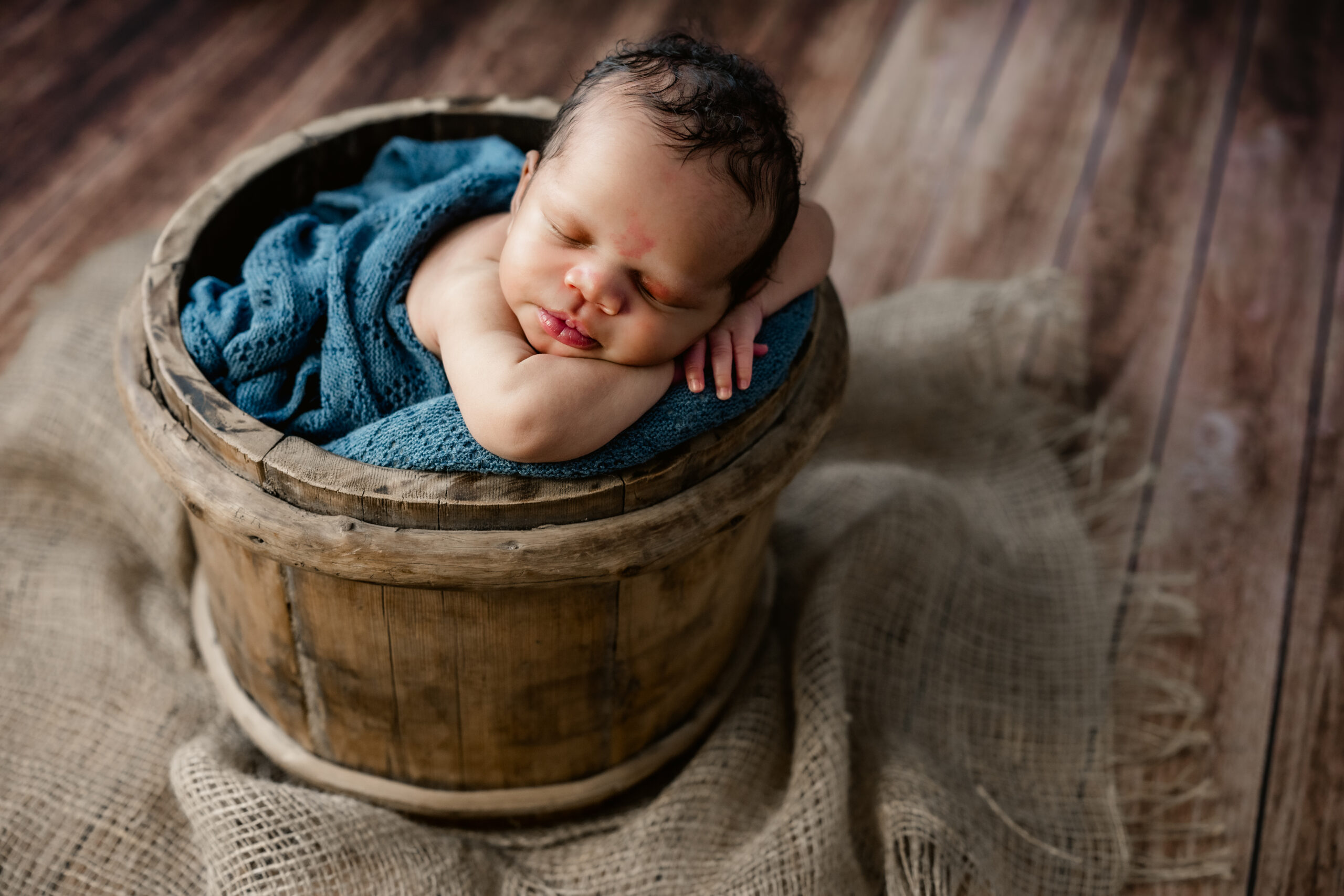 baby poses in bucket during in-home photo session in atlanta