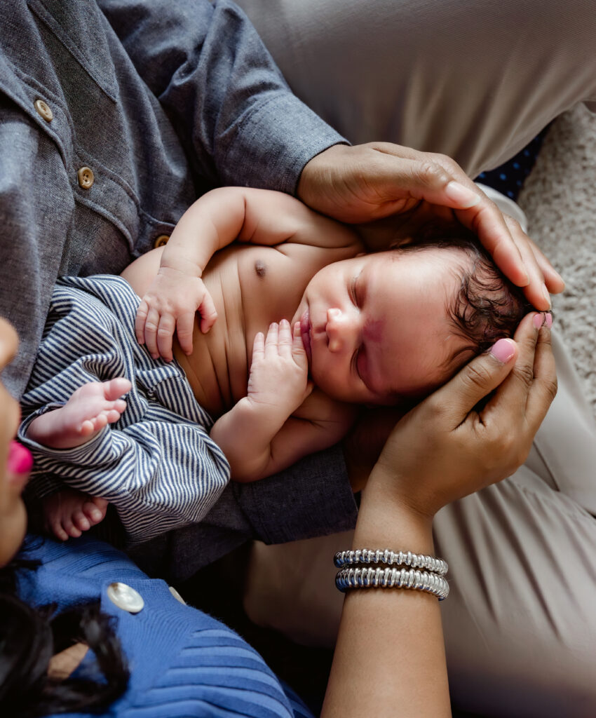 newborn baby boy being held in parents arms
