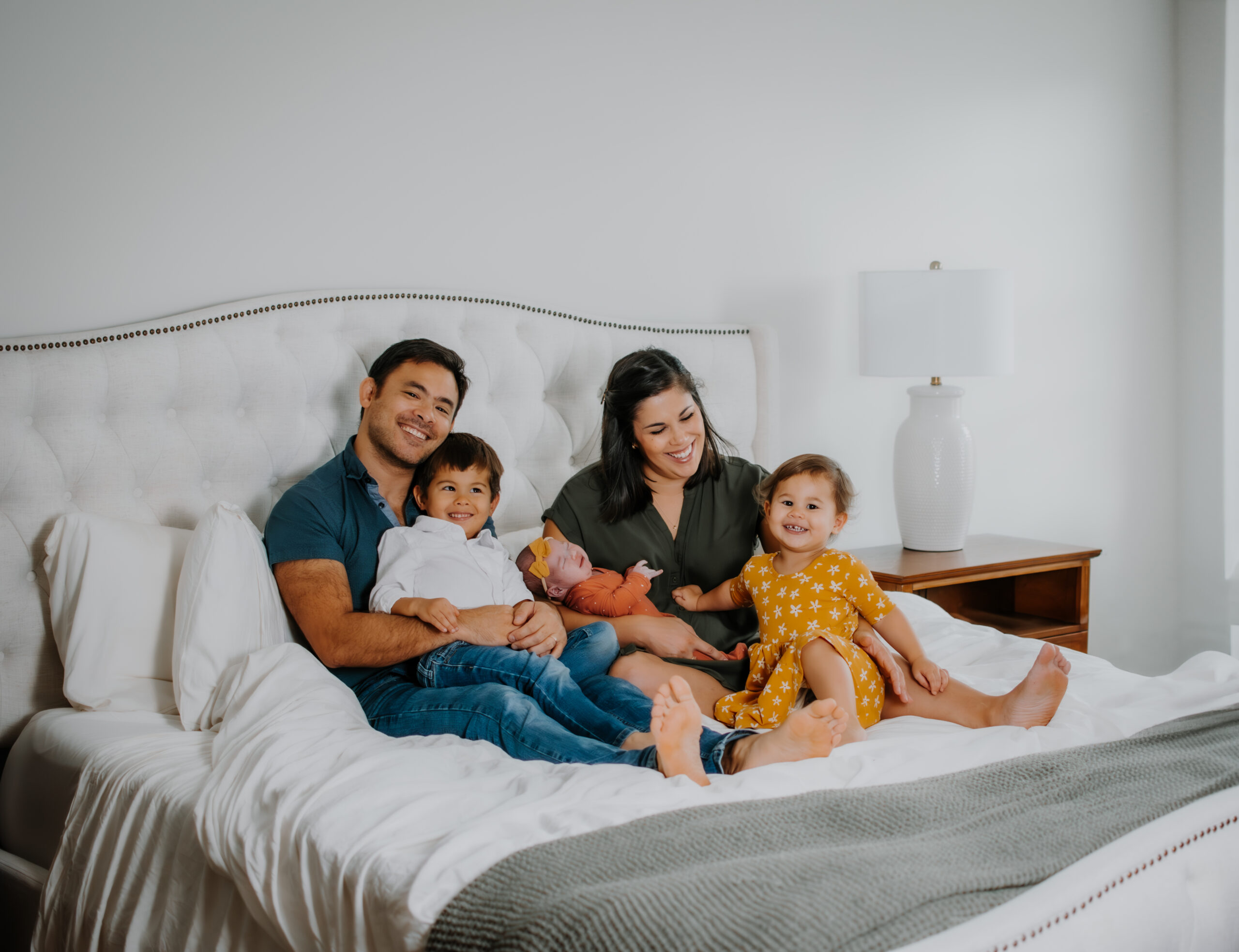 Family on bed during in-home newborn session in Atlanta georgia