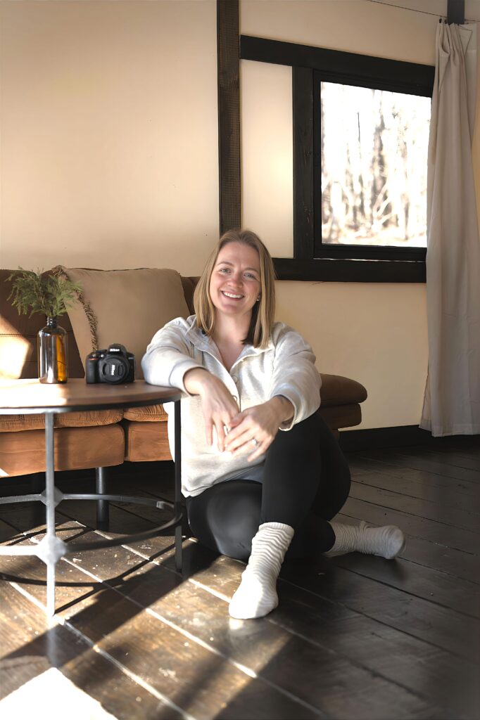 photographer sits on floor and leans on table in branding image