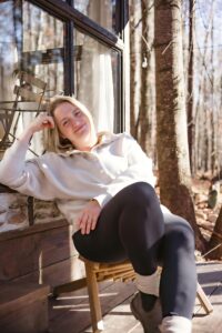 atlanta photographer leans against window during branding photoshoot