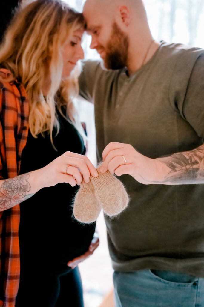 Couple stands with baby mittens in focus during Atlanta maternity session