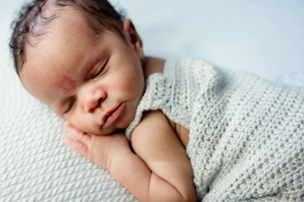 Newborn baby in blue knit romper