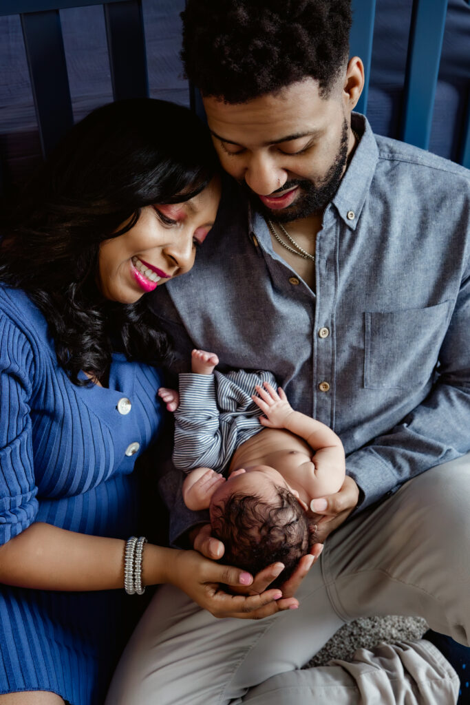 Close up of mom and dad holding baby during newborn session