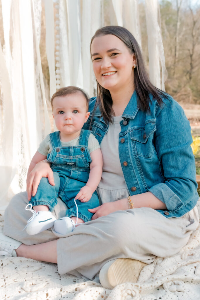 mom and son sit on ground smiling at camera at Lilburn City Park