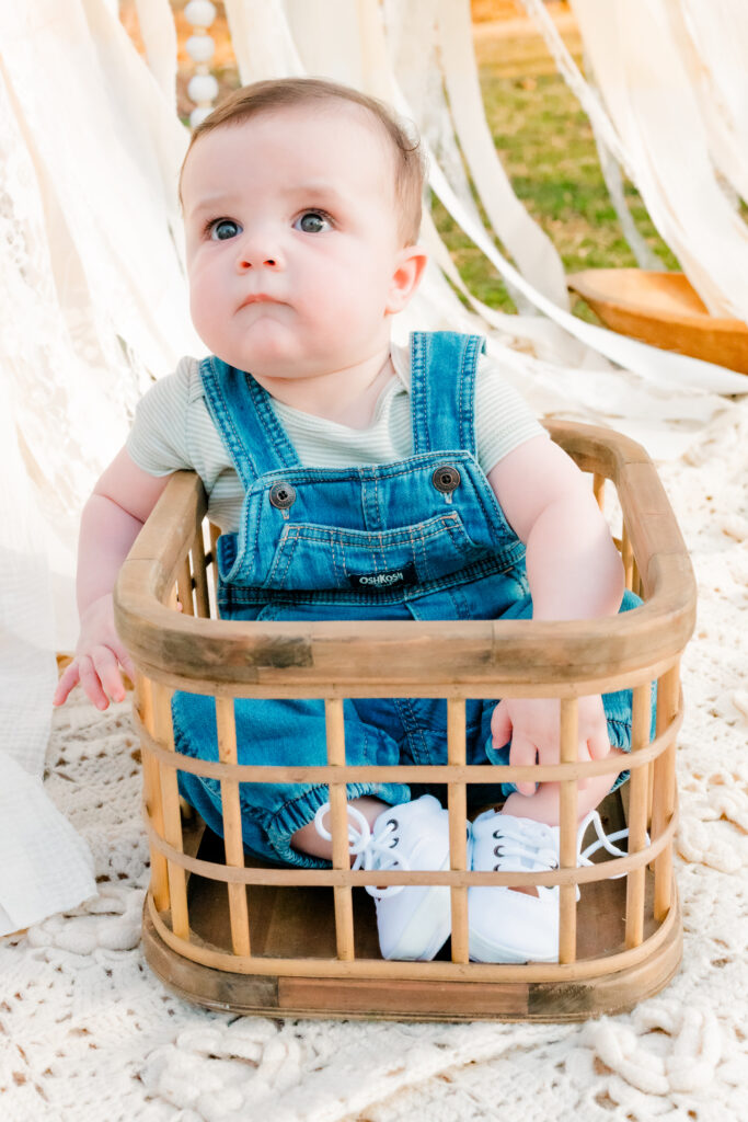 Little boy sits in Hello Little Props crate at Lilburn City Park