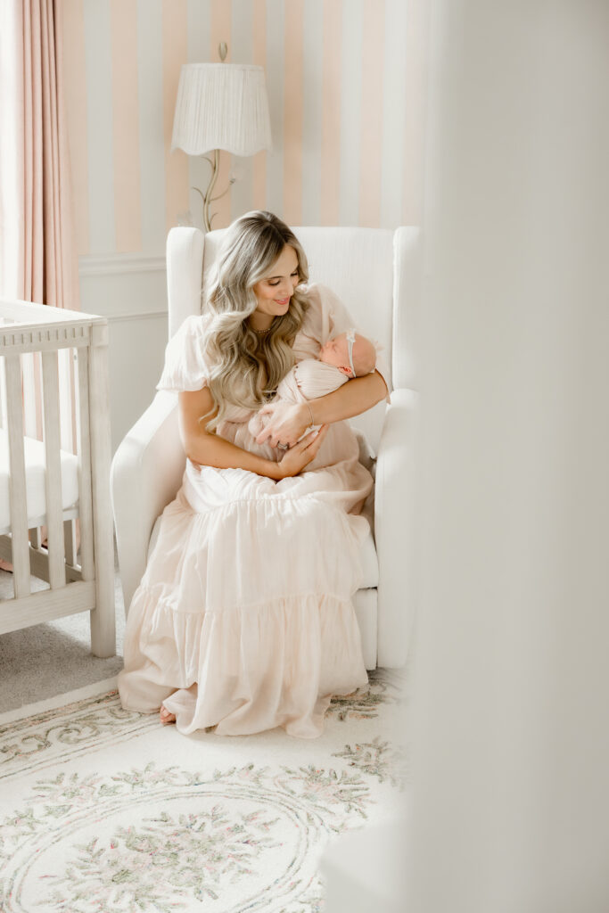 mom holds her newborn baby during in-home newborn session