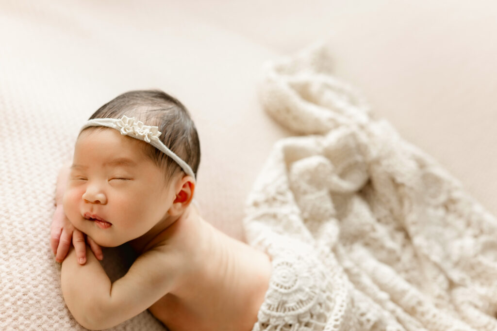 newborn photo of sleeping baby with chin propped on hands