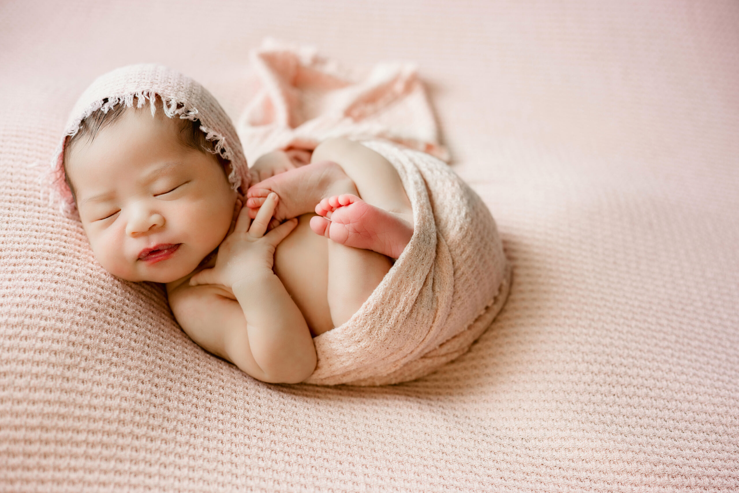 newborn photographed on pink backdrop in Lawrenceville, Georiga