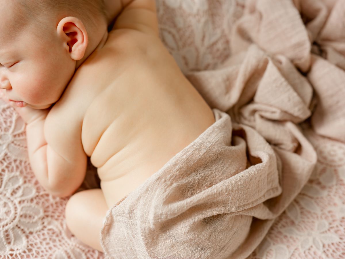 Newborn photo of baby posed in pink fabric