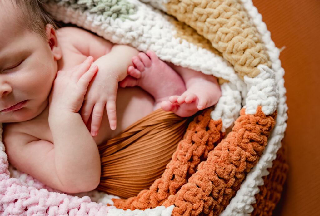 Newborn wrapped in colorful heirloom knit during Tucker, Georgia newborn photography session. 