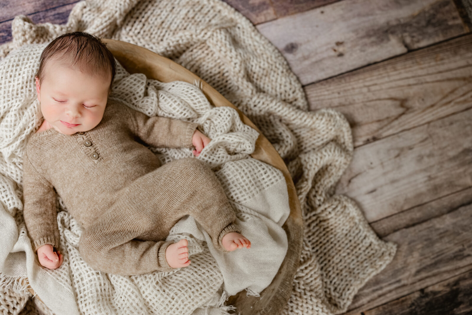 Sleeping newborn posed in a basket with natural fibers during Tucker, Georgia in-home newborn session. 